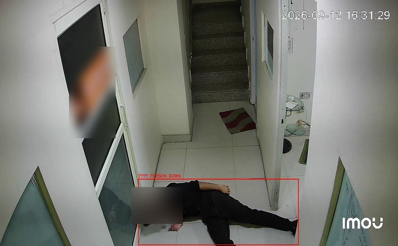 A person lying on a corridor floor, boxed and labelled PERSON DOWN; the face is blurred